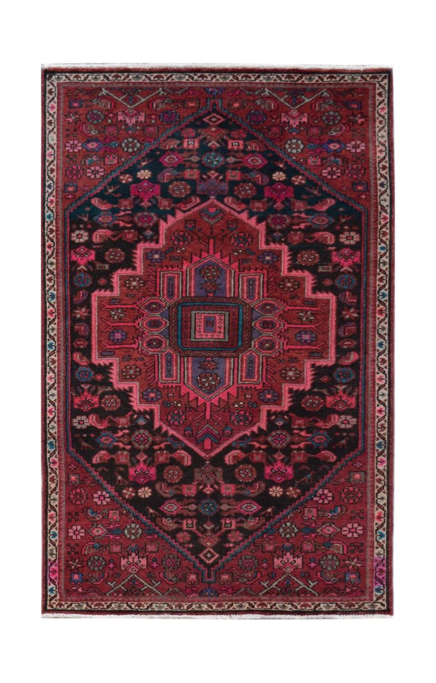 A rectangular handmade Persian wool rug featuring a geometric medallion pattern in red and black.