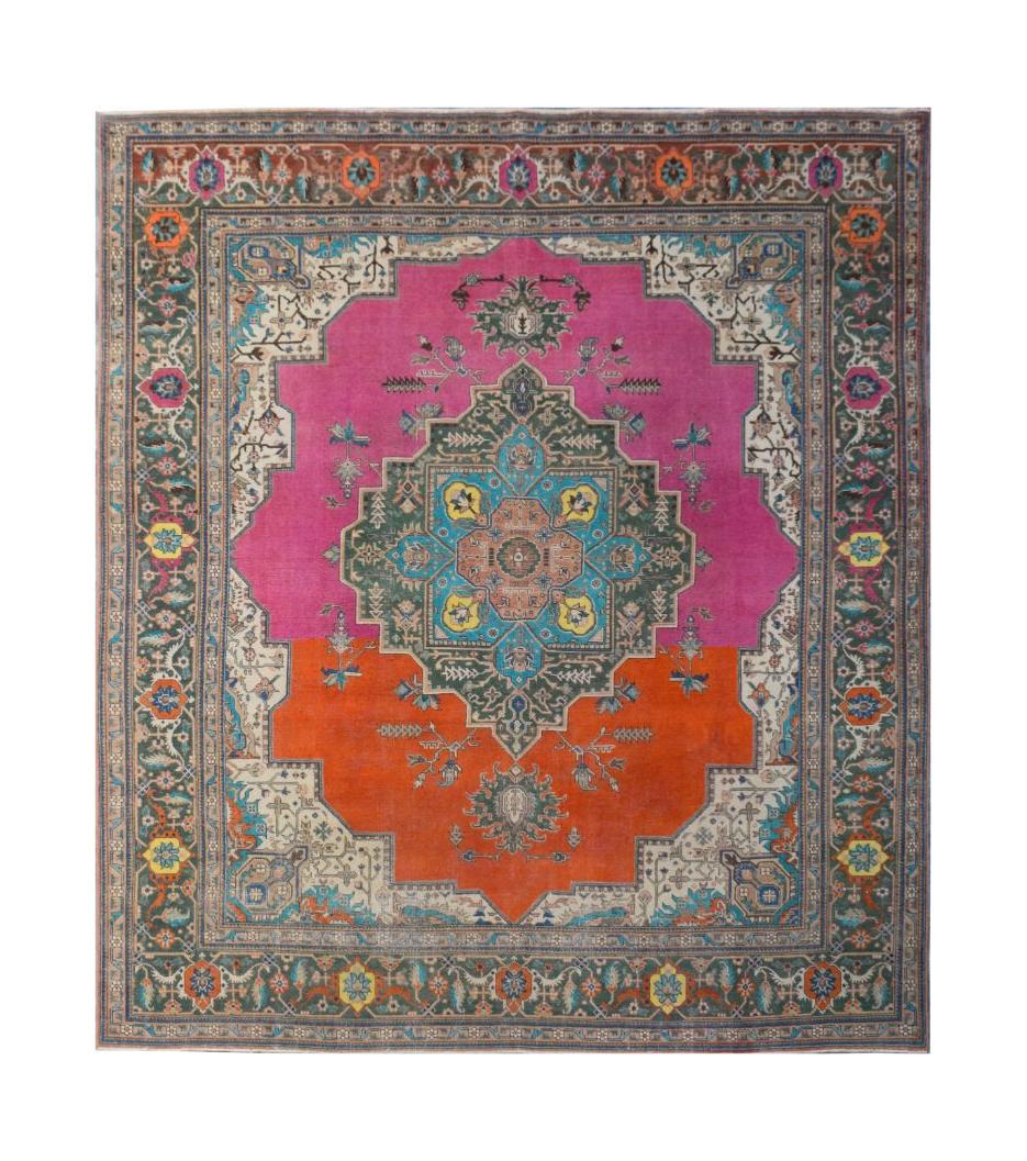 A vintage Persian rug featuring a central medallion on a split pink and orange field.