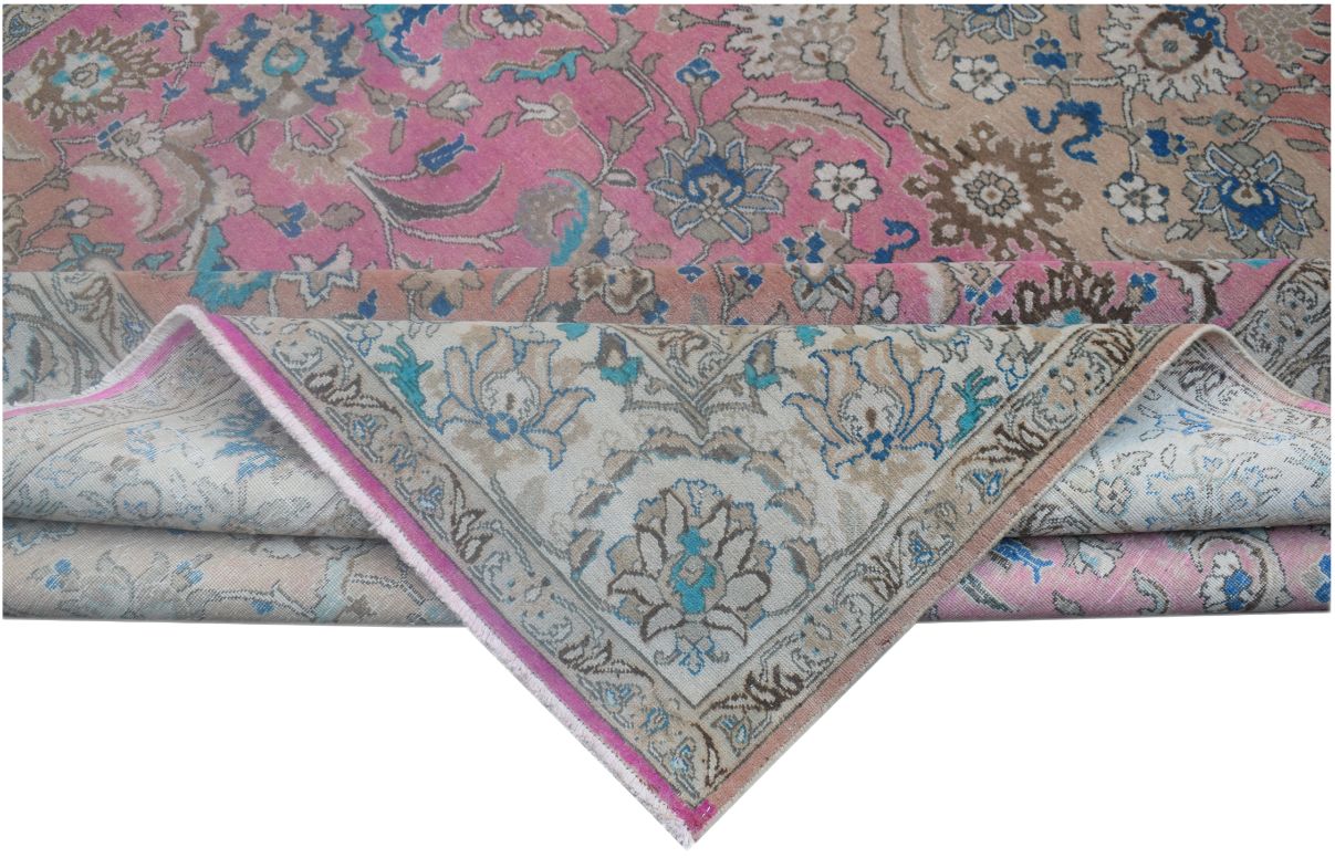 A vintage handmade Persian wool rug featuring a floral pattern in pink, blue, and beige tones.