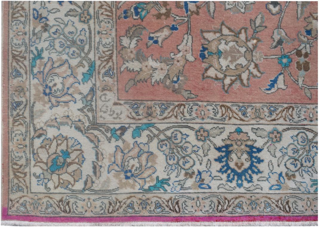 A vintage Persian wool rug featuring a floral pattern in shades of pink, blue, and cream.