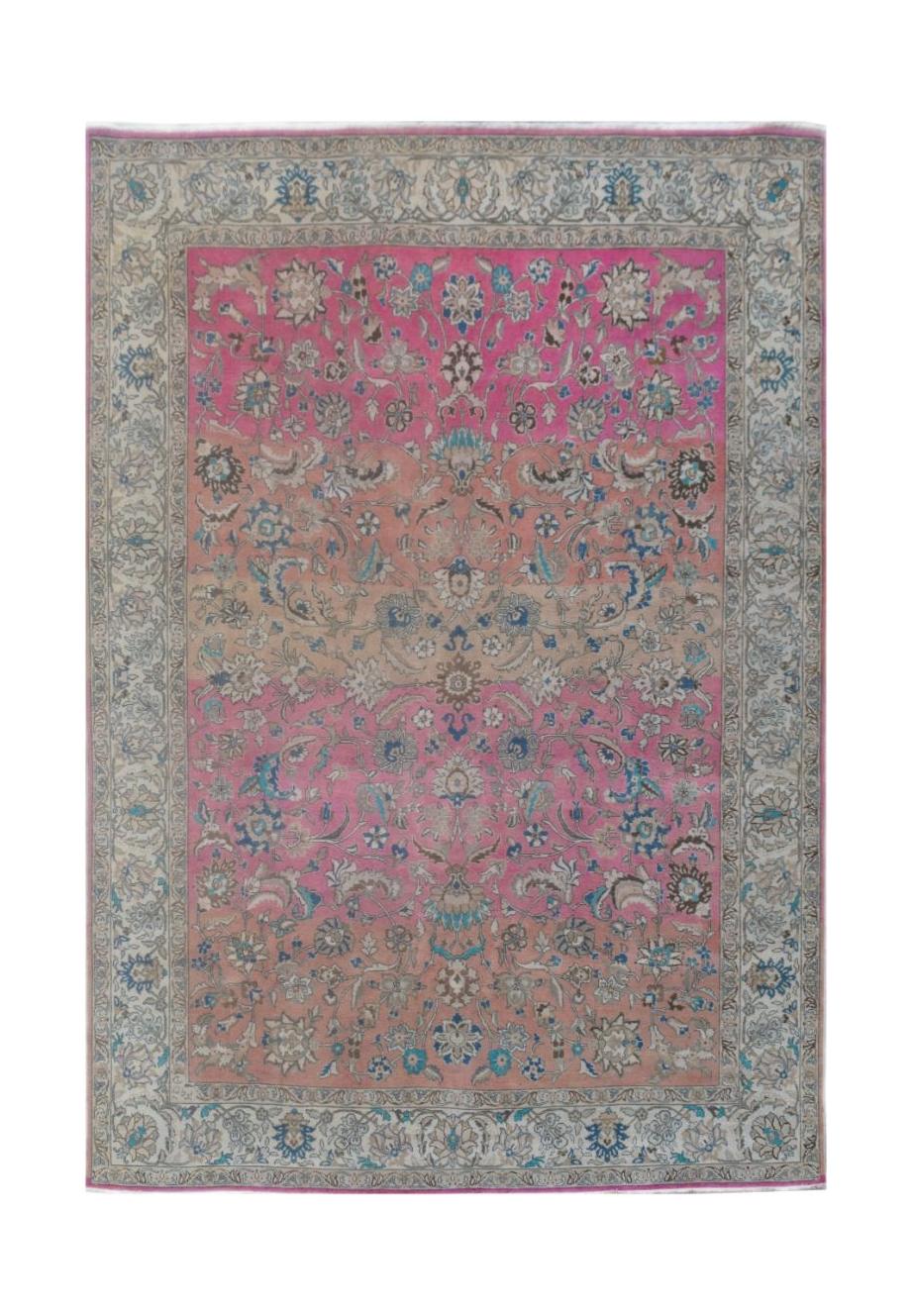 A handmade vintage Persian wool rug featuring a floral pattern with a pink and orange ombre effect.