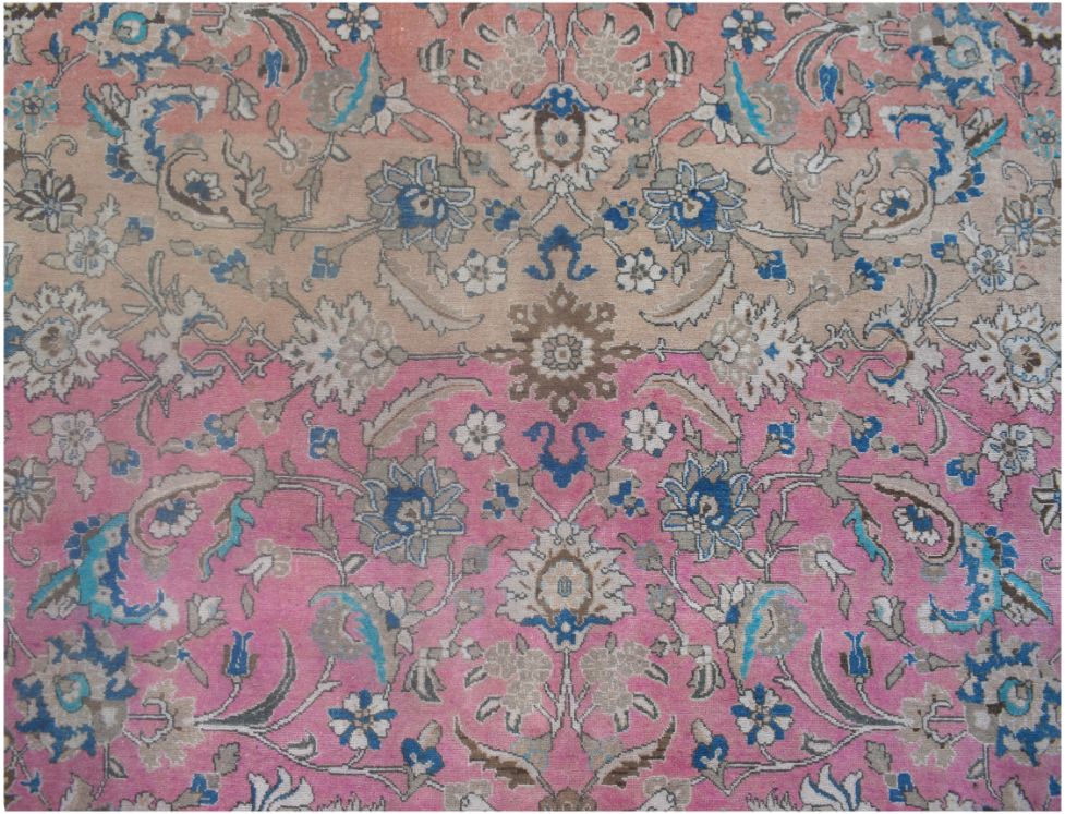 A vintage Persian wool rug featuring a floral pattern with a pink and beige abrash color gradient.
