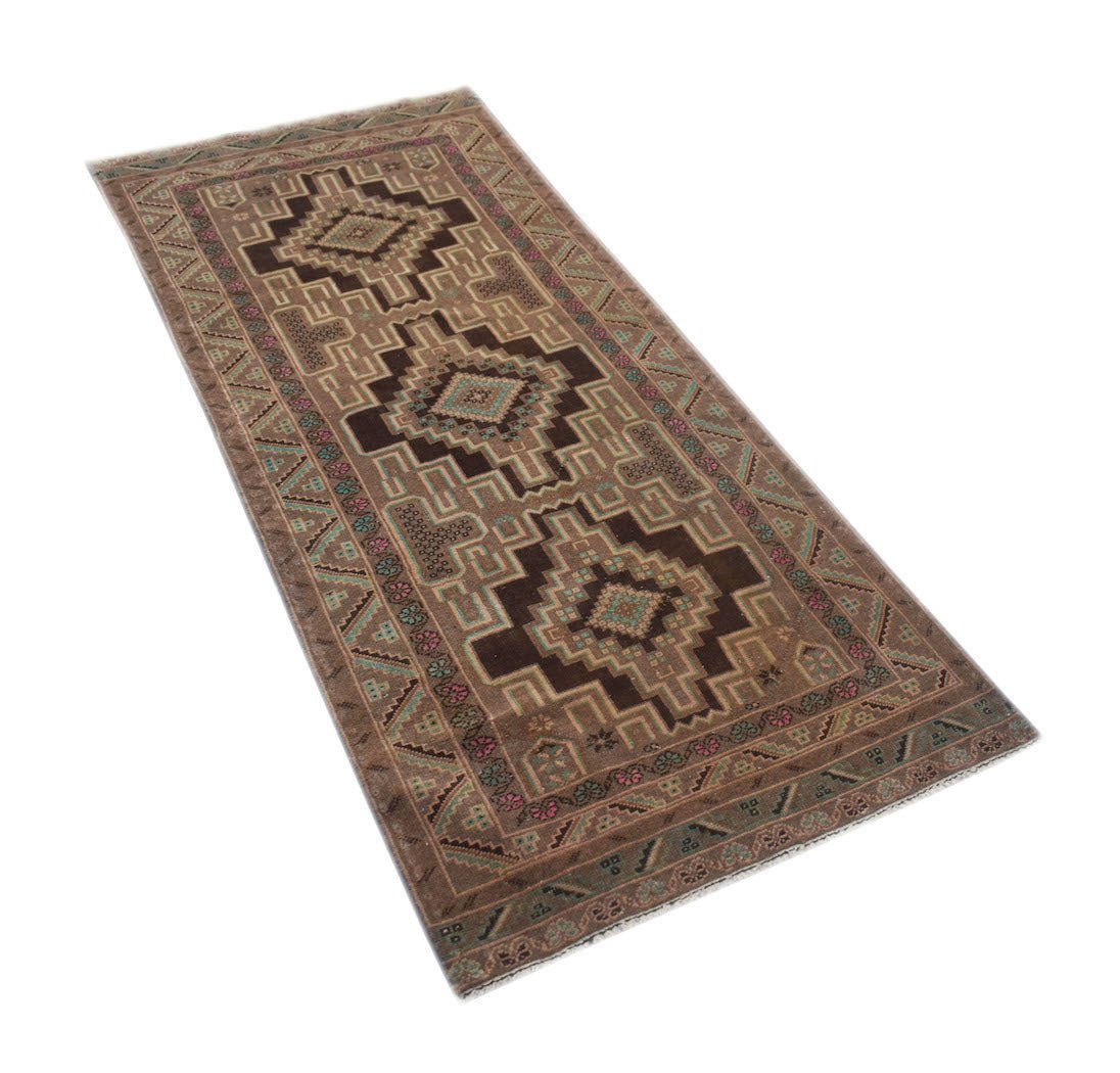 A vintage Afghan Baluch runner rug featuring geometric patterns in brown, teal, and pink wool.