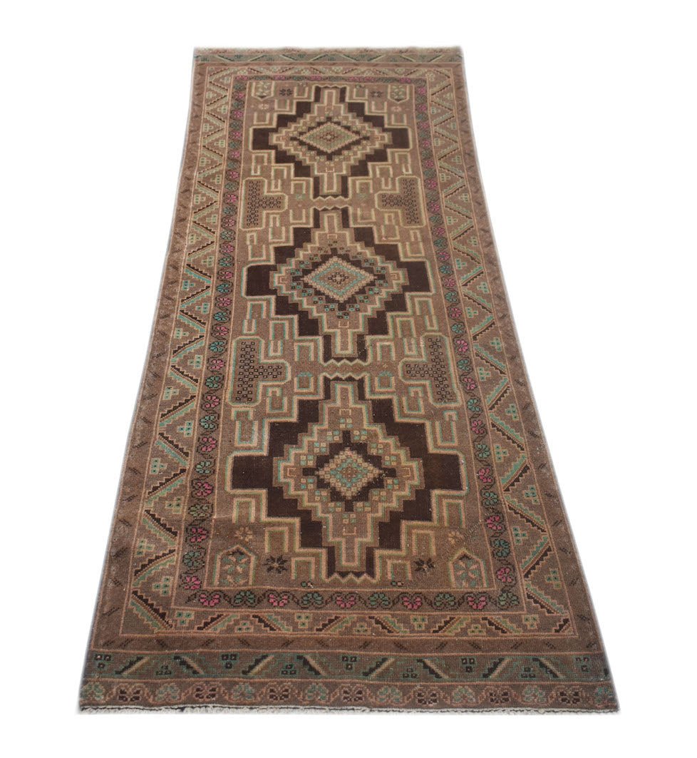 A handmade vintage Afghan Baluch runner featuring geometric diamond motifs in brown and tan wool.