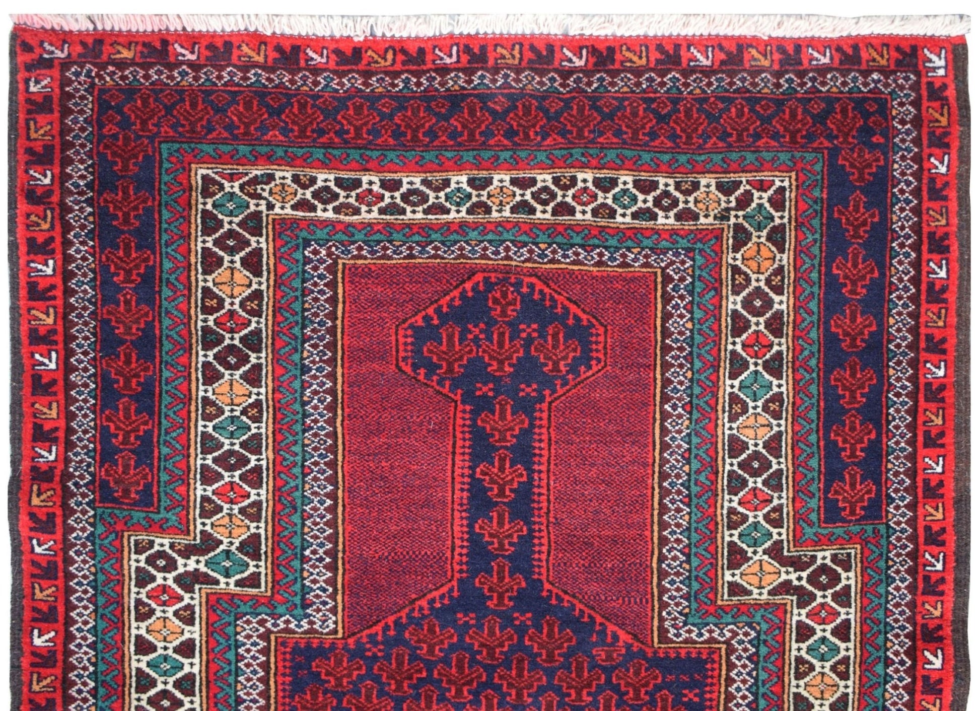A vintage handmade Afghan Baluch rug featuring a geometric prayer design in red, blue, and ivory.