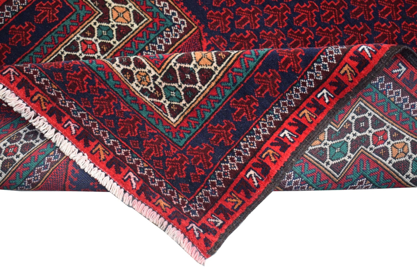 A folded vintage Afghan Baluch rug featuring traditional geometric patterns in red, blue, and ivory.