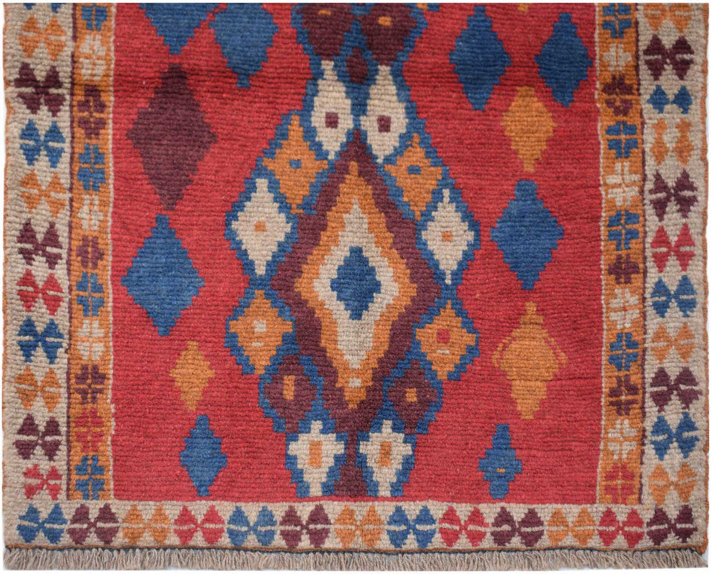 Handmade Afghan Pashm rug featuring a geometric diamond pattern in red, blue, and ivory wool.