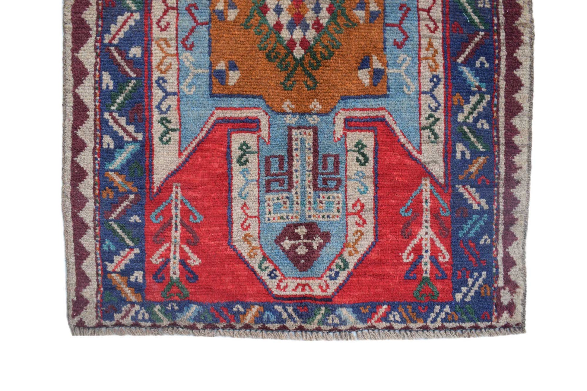 A handmade Afghan Pashm rug featuring a geometric tribal pattern in red, blue, and orange wool.