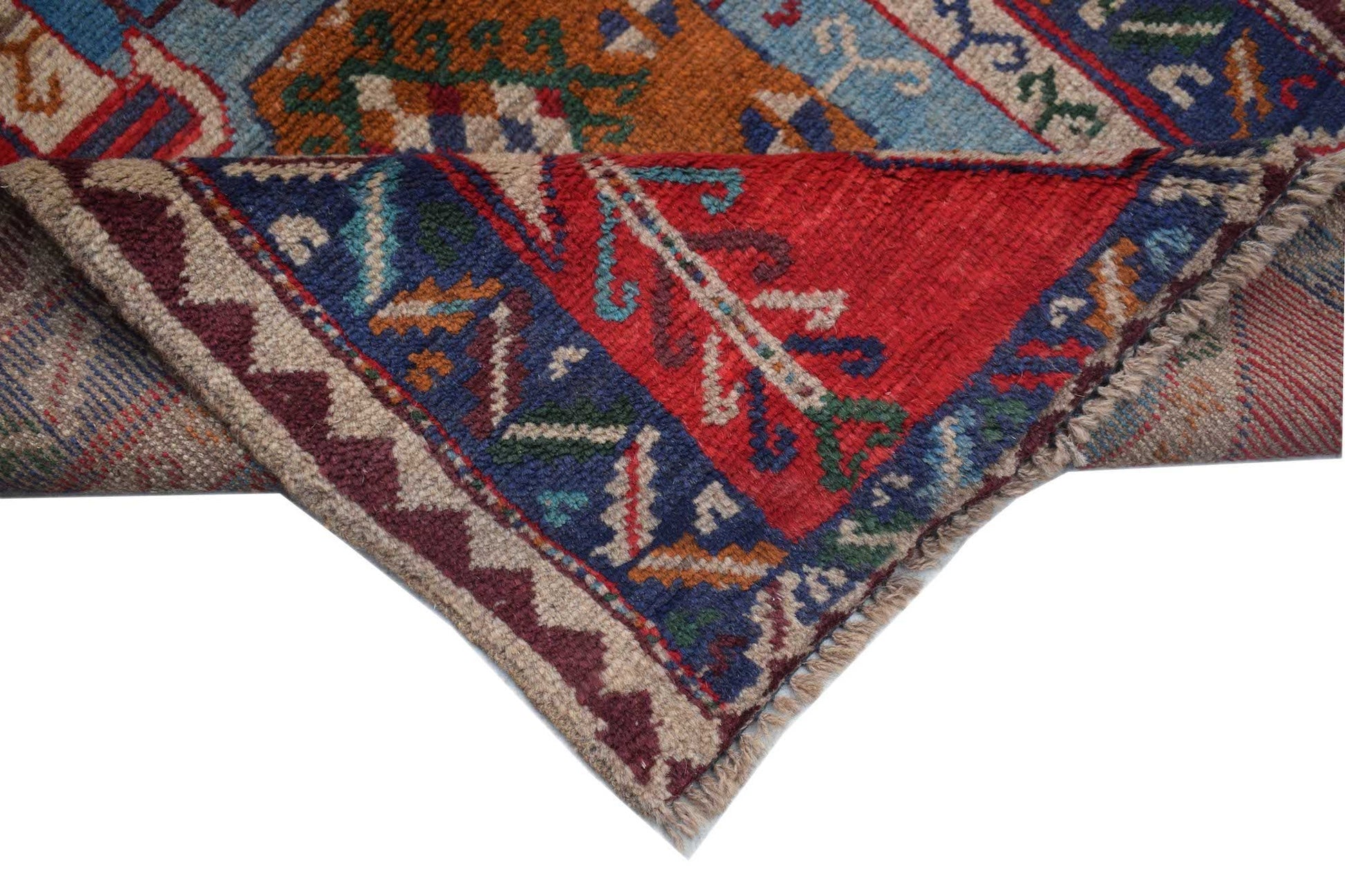 A handmade Afghan Pashm rug featuring traditional tribal patterns in deep red, blue, and ivory.