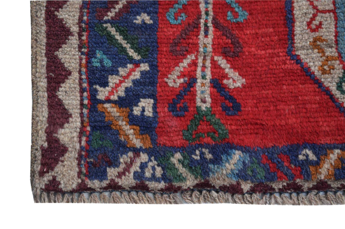 A handmade Afghan Pashm rug featuring a traditional tribal pattern in deep red, blue, and ivory.