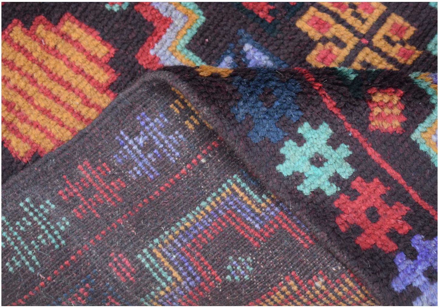 A handmade Afghan Pashm rug featuring geometric tribal patterns in dark red, blue, and brown wool.