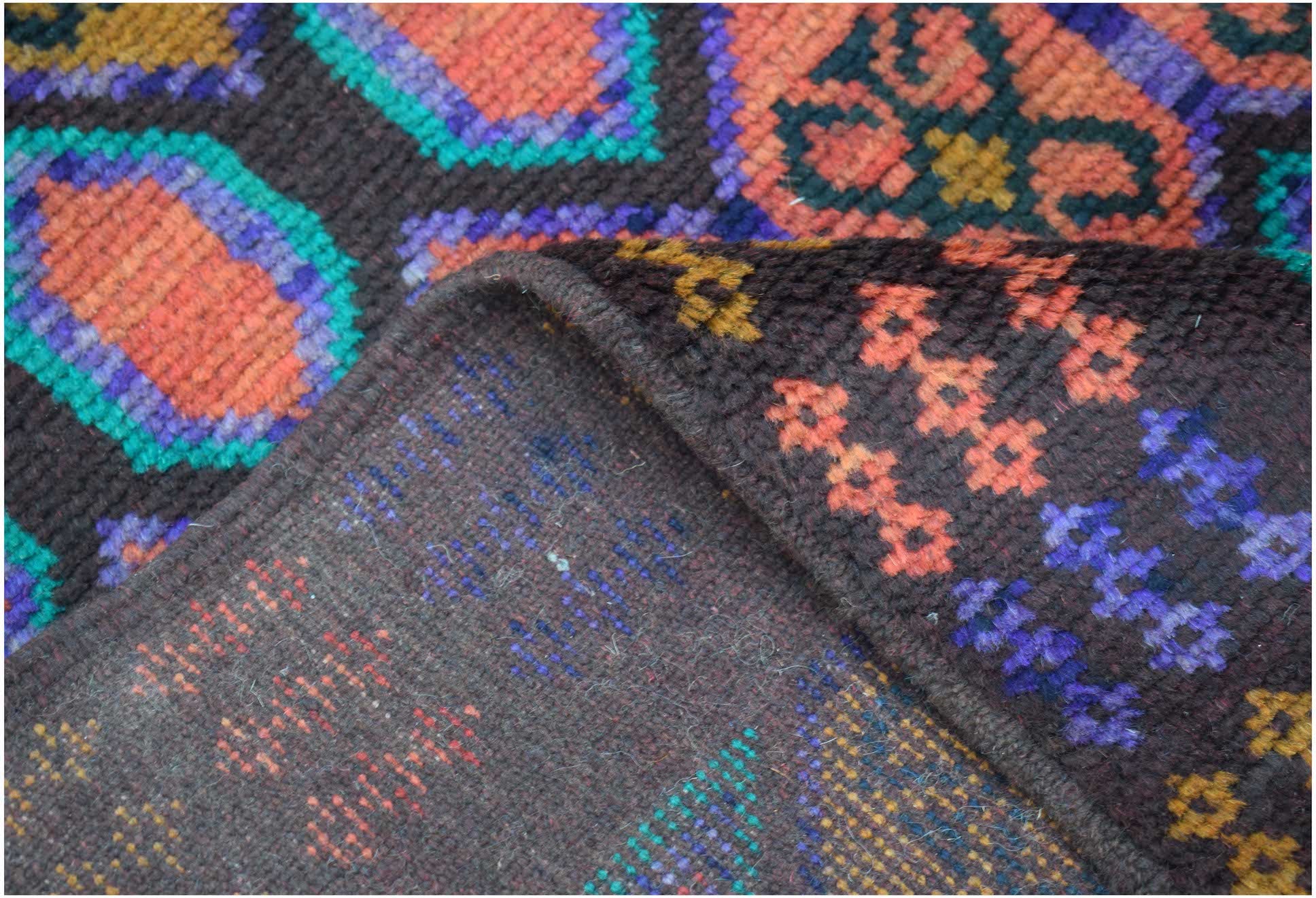 A handmade Afghan Pashm rug featuring a dark brown background with vibrant geometric patterns.