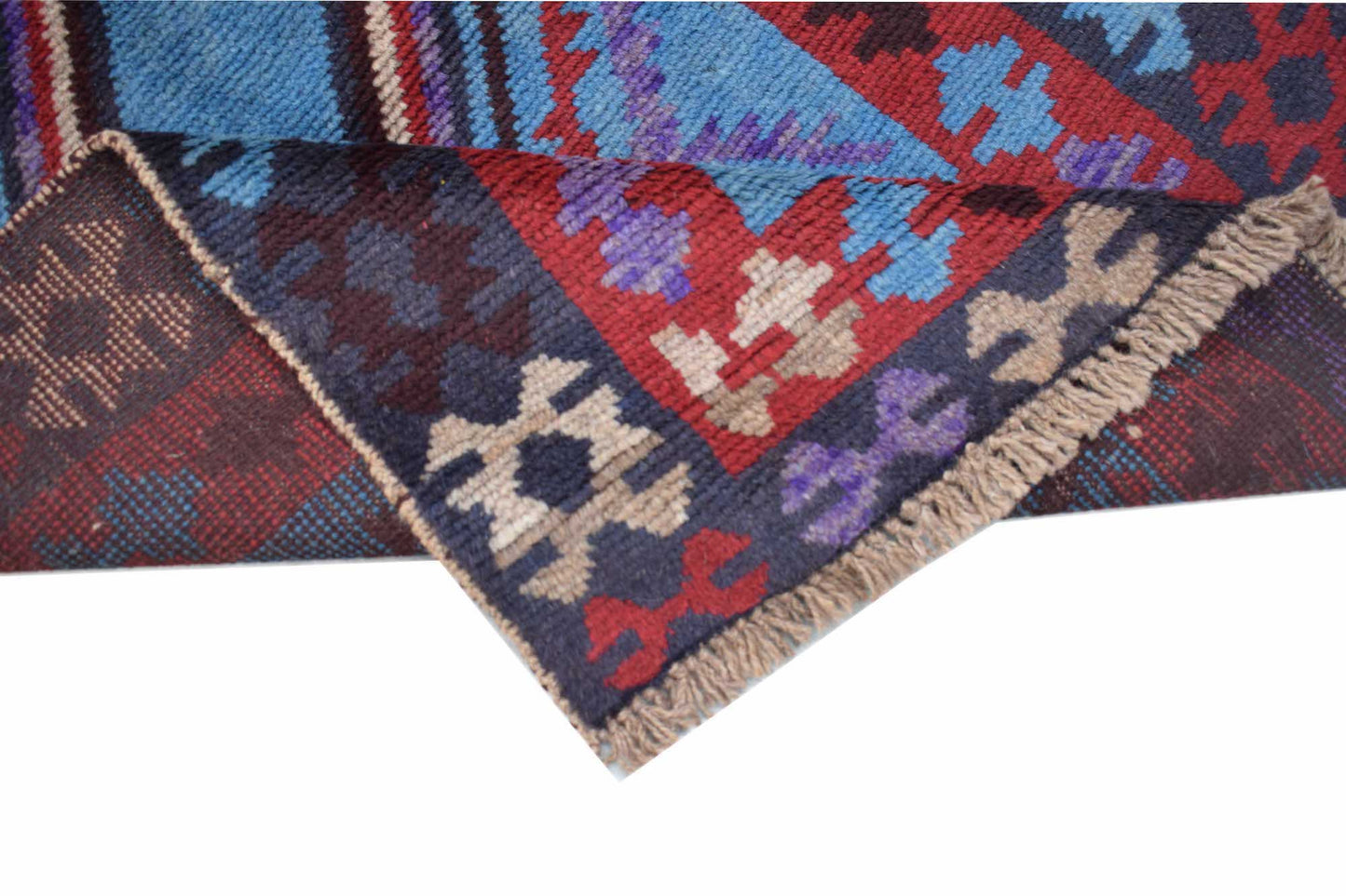 A handmade Afghan Pashm rug featuring a geometric tribal pattern in deep red, blue, and brown tones.