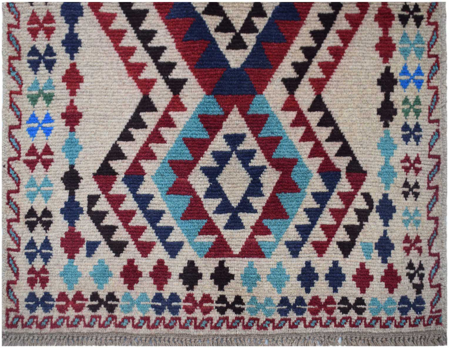 Handmade Afghan Pashm rug featuring a geometric tribal pattern in red, blue, and ivory wool.