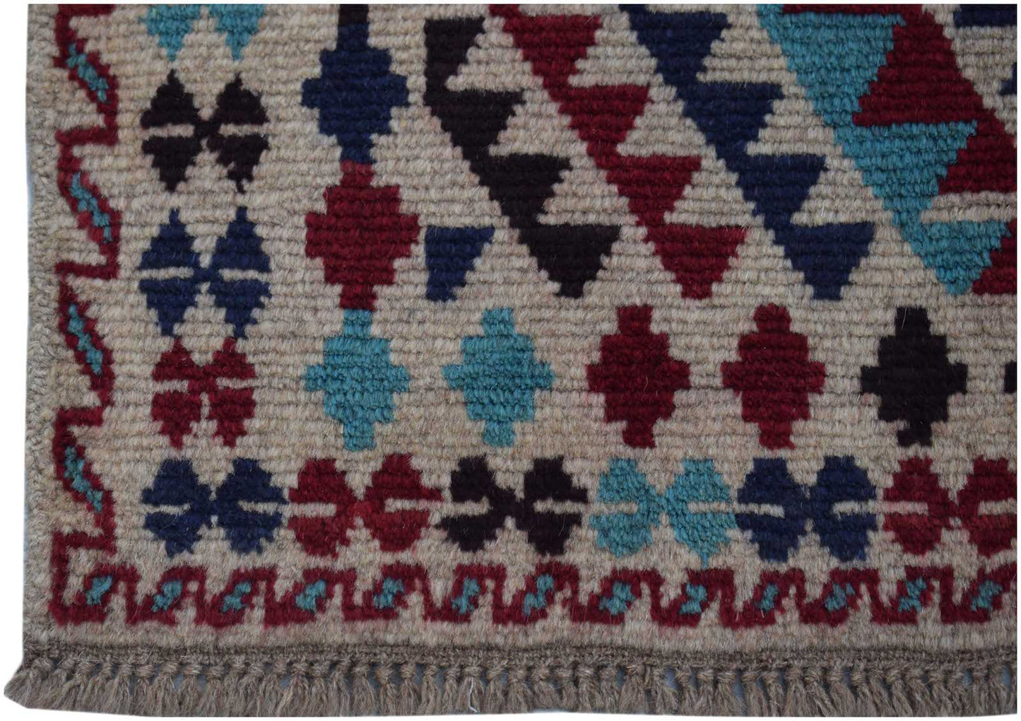 Handmade Afghan Pashm rug featuring geometric tribal patterns in red, blue, and dark brown wool.