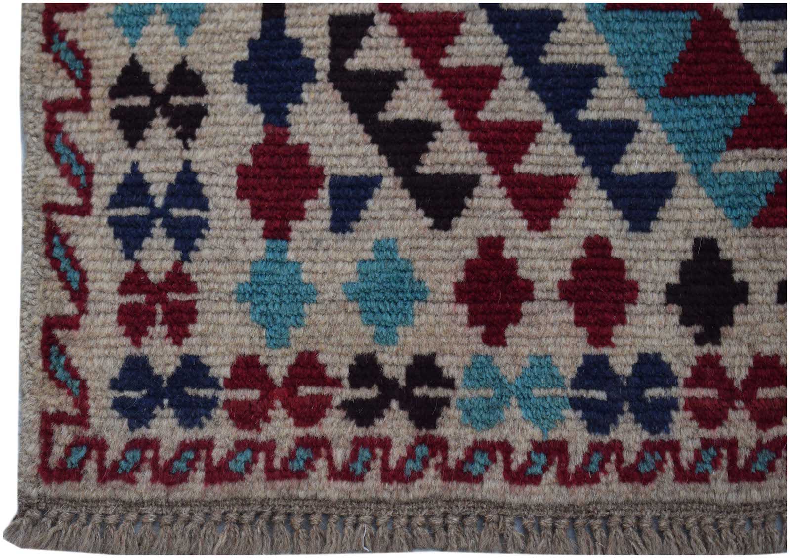 Handmade Afghan Pashm rug featuring geometric tribal patterns in red, blue, and dark brown wool.