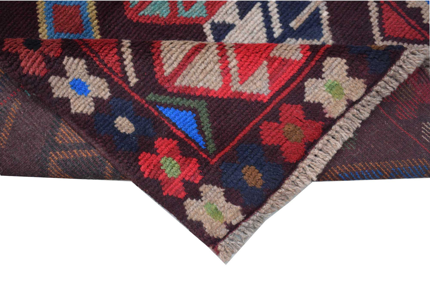 A handmade Afghan Pashm rug featuring traditional tribal geometric patterns in deep red, blue, and brown.