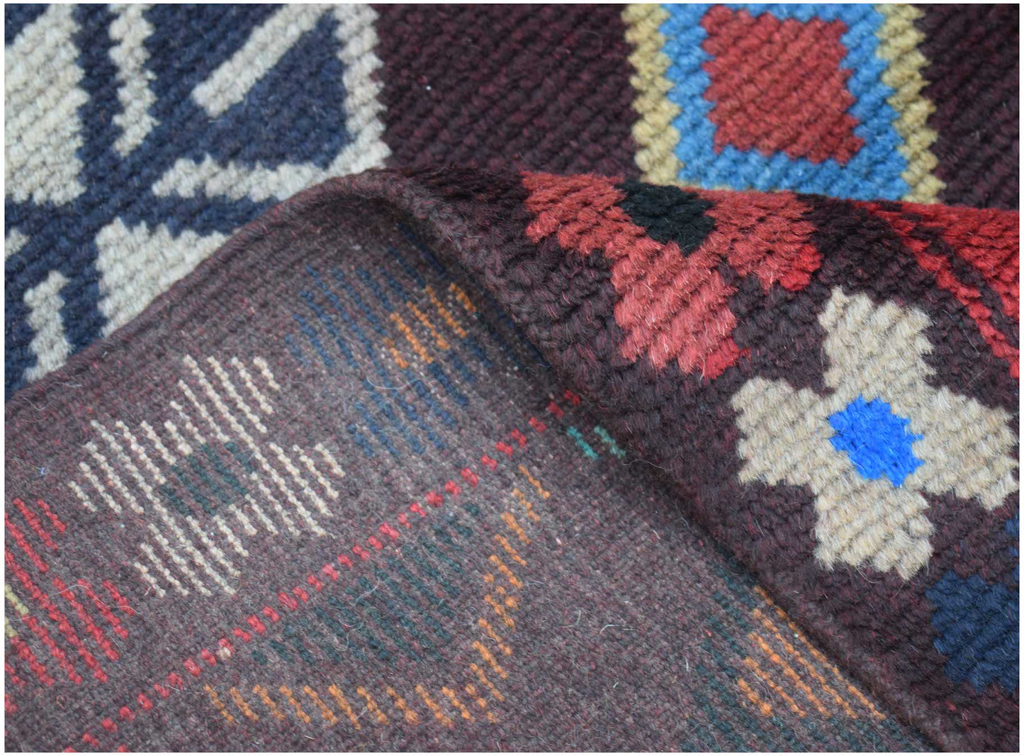 A handmade Afghan Pashm rug featuring a dark brown base with geometric patterns in red and blue.