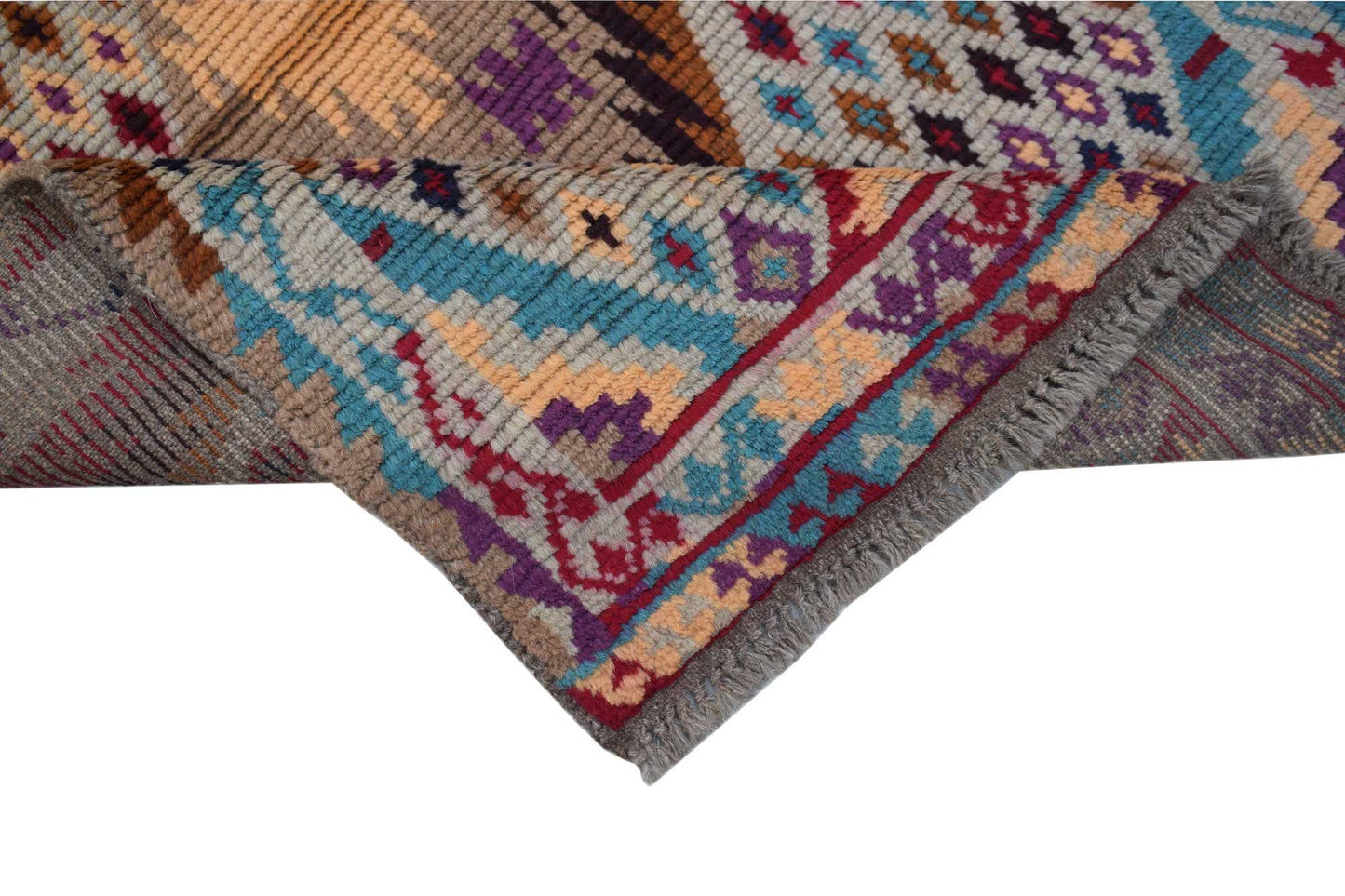 Handmade Afghan Pashm rug featuring a tribal geometric pattern in red, blue, and brown wool.