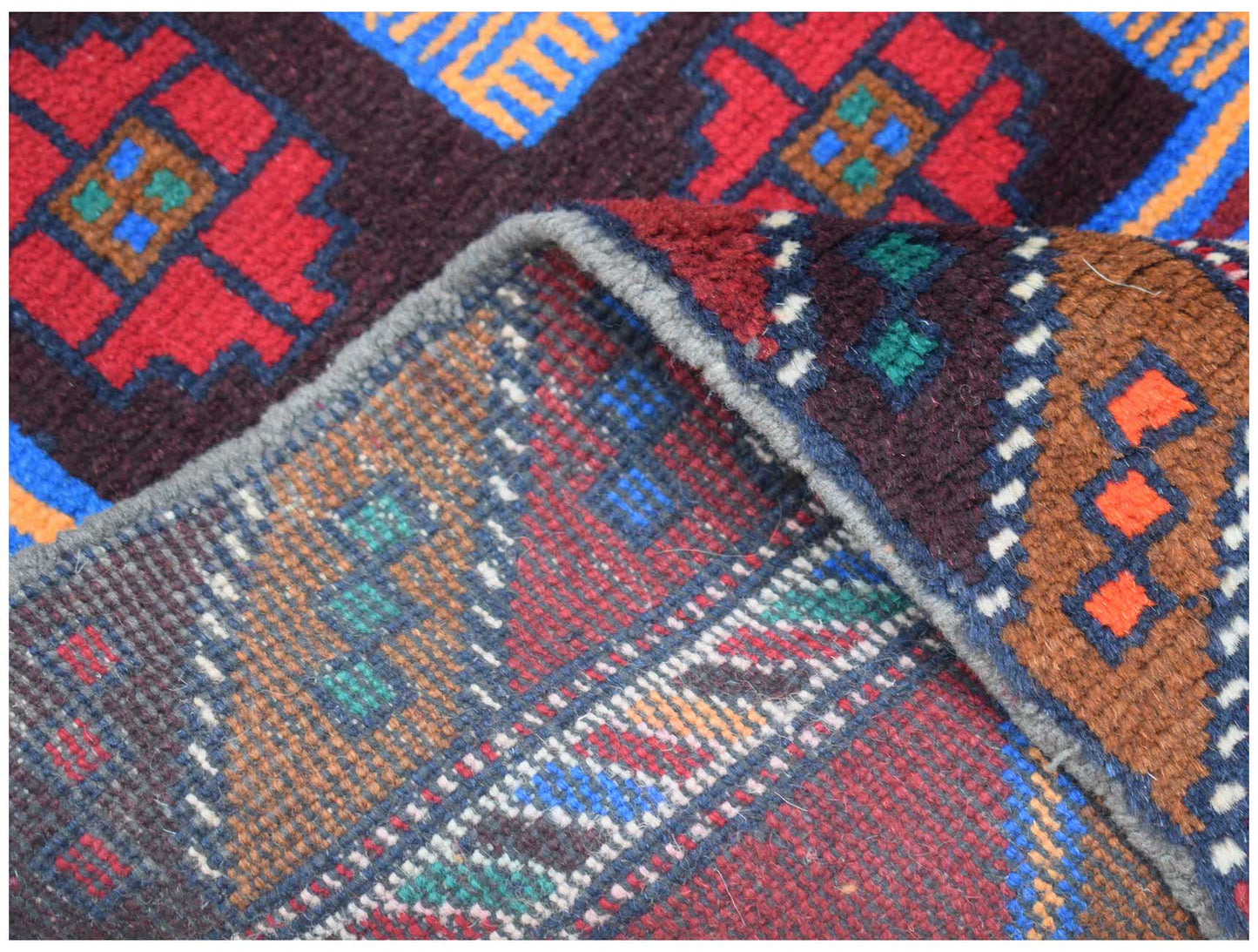 A handmade Afghan Pashm rug featuring geometric patterns in dark red, brown, and blue wool.