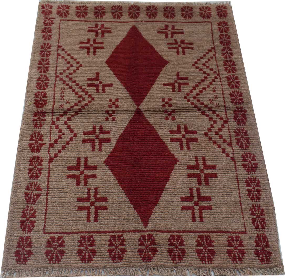 Handmade Afghan Pashm rug featuring a geometric diamond pattern in dark red on a brown wool base.