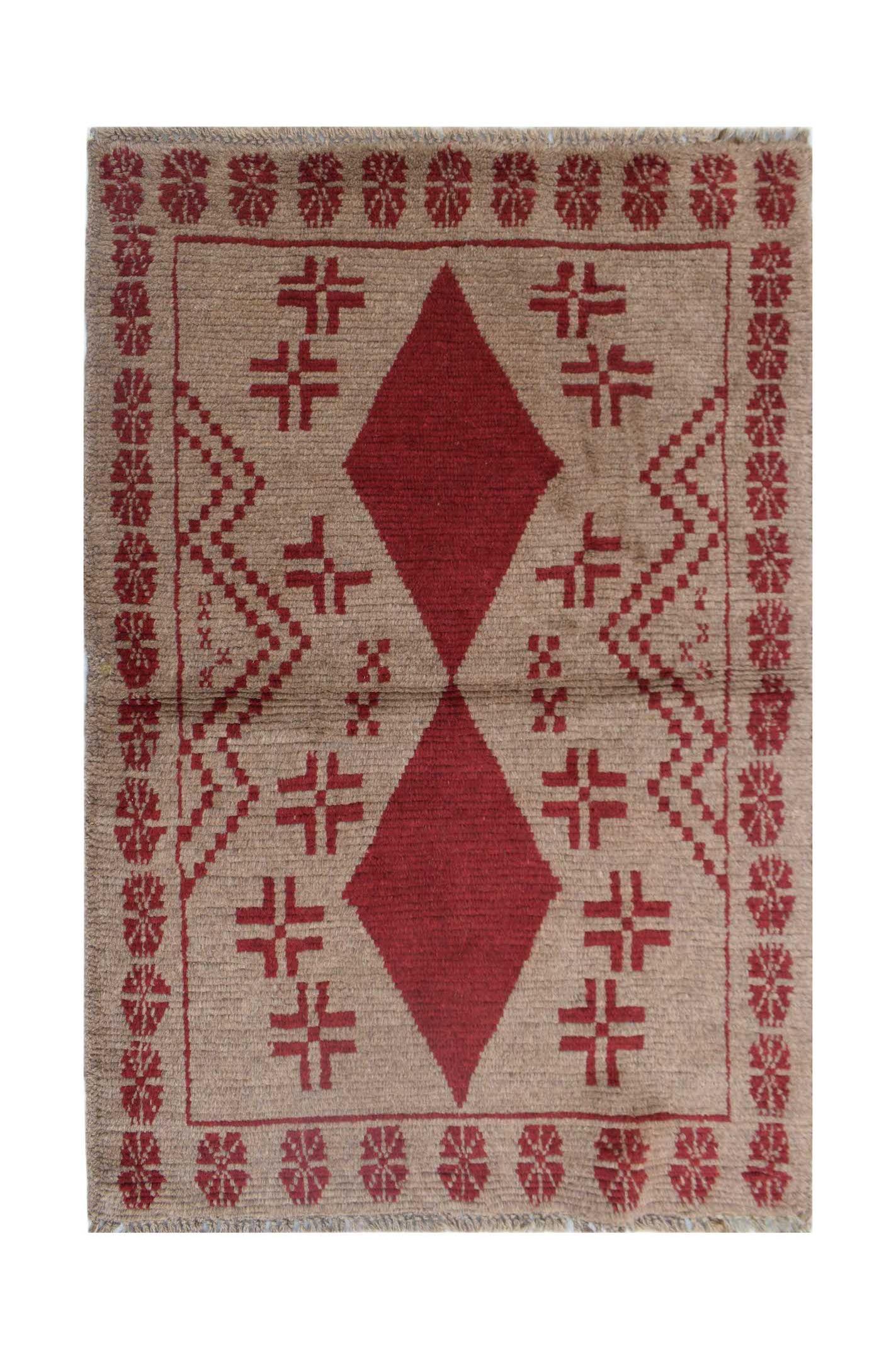 Handmade Afghan Pashm rug featuring a red diamond pattern on a tan wool background.