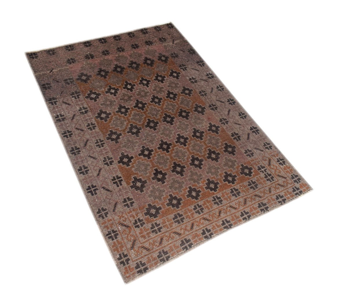 A handmade vintage Afghan Baluch rug featuring a geometric pattern in shades of brown and grey.