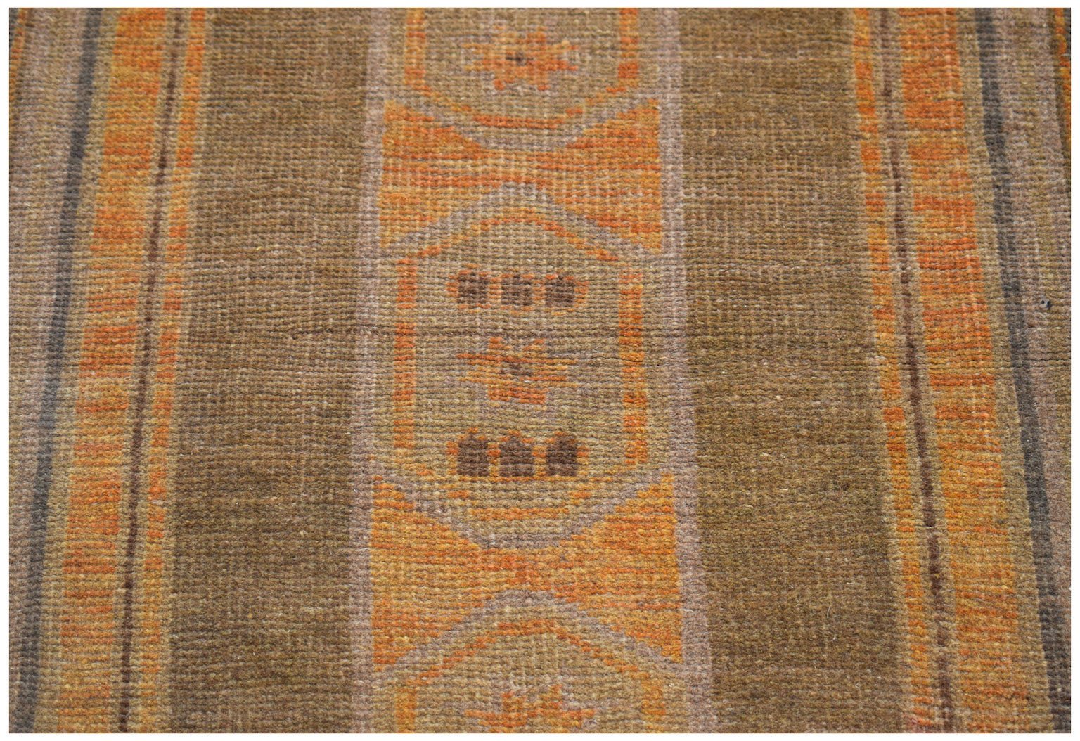 A handmade Afghan Baluch rug featuring geometric patterns in shades of brown and orange.