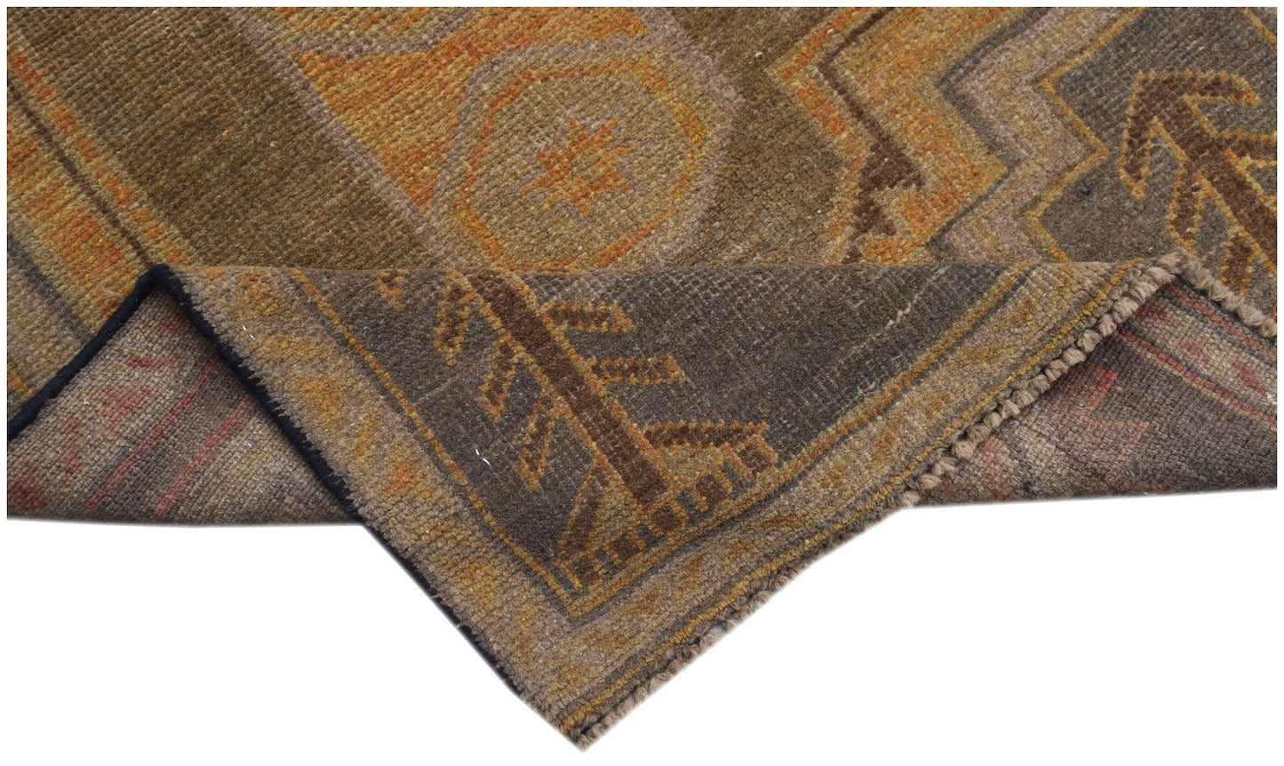 A handmade Afghan Baluch rug featuring geometric patterns in shades of brown and orange.