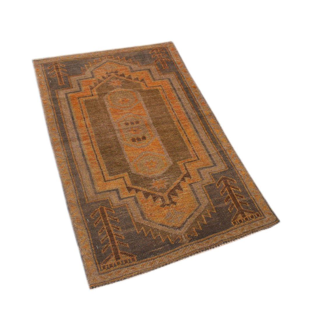 An Afghan Baluch rug featuring a geometric pattern in shades of brown and orange.
