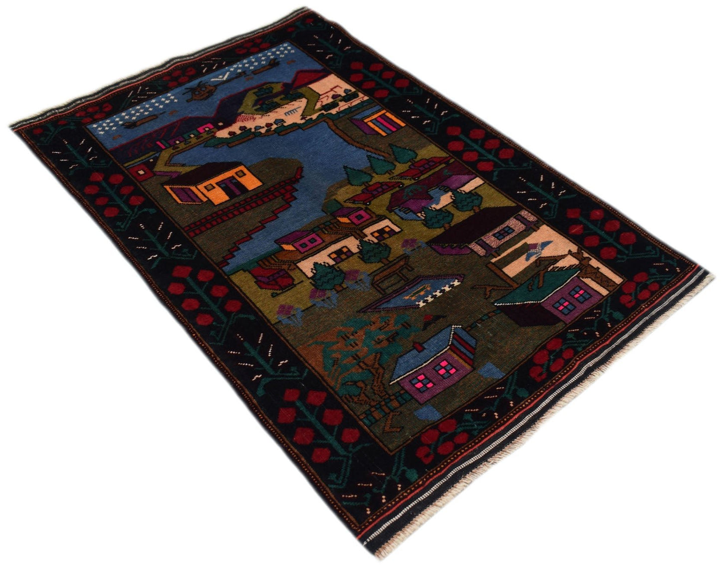 A handmade Afghan Baluch rug featuring a colorful village landscape scene on a dark background.