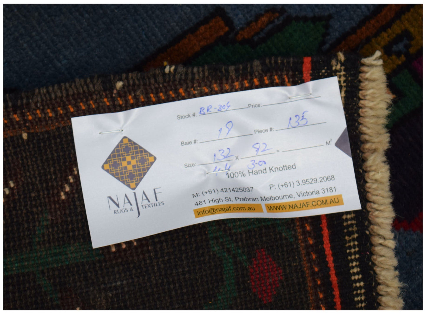 An Afghan Baluch rug featuring a dark pattern with red, brown, and blue tones.