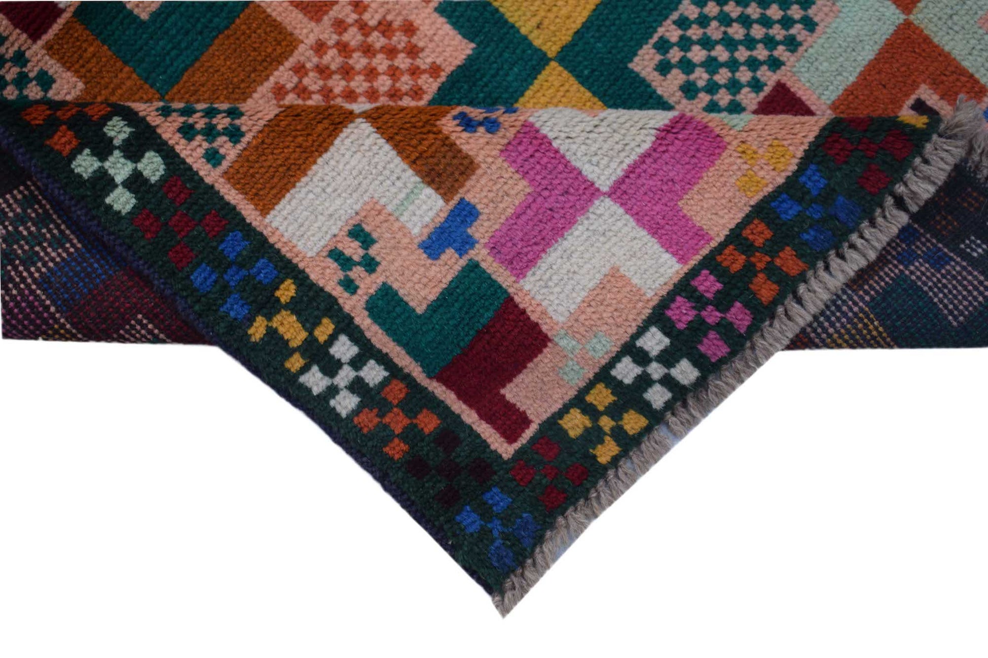 A handmade Afghan Pashm rug featuring a geometric pattern in vibrant colors with a fringed edge.