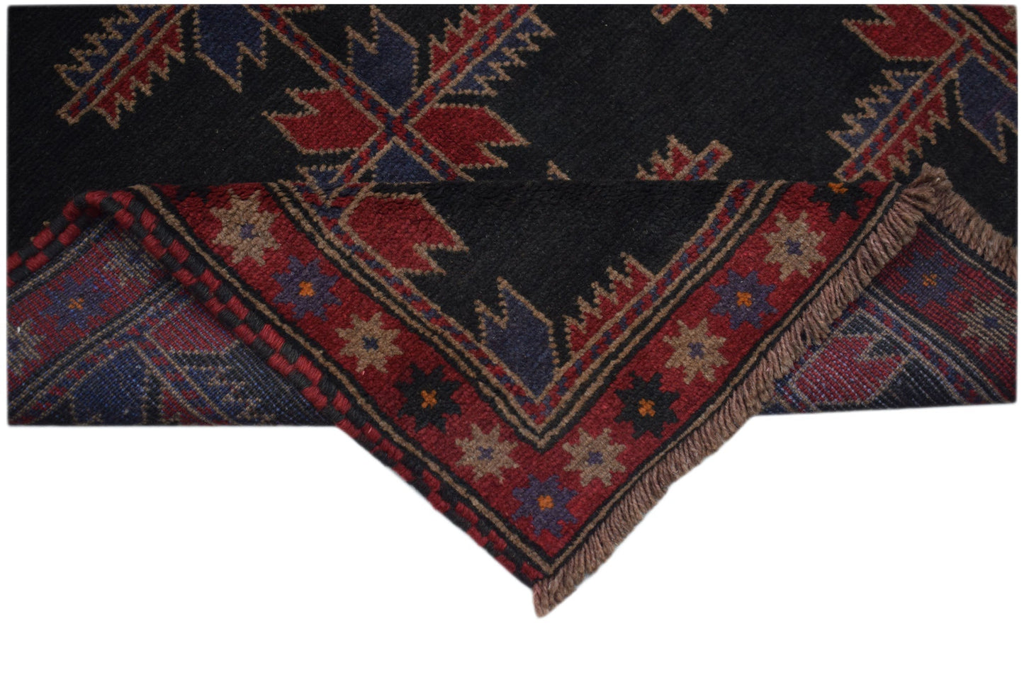 A handmade Afghan Baluch rug featuring traditional geometric patterns in red, blue, and black.
