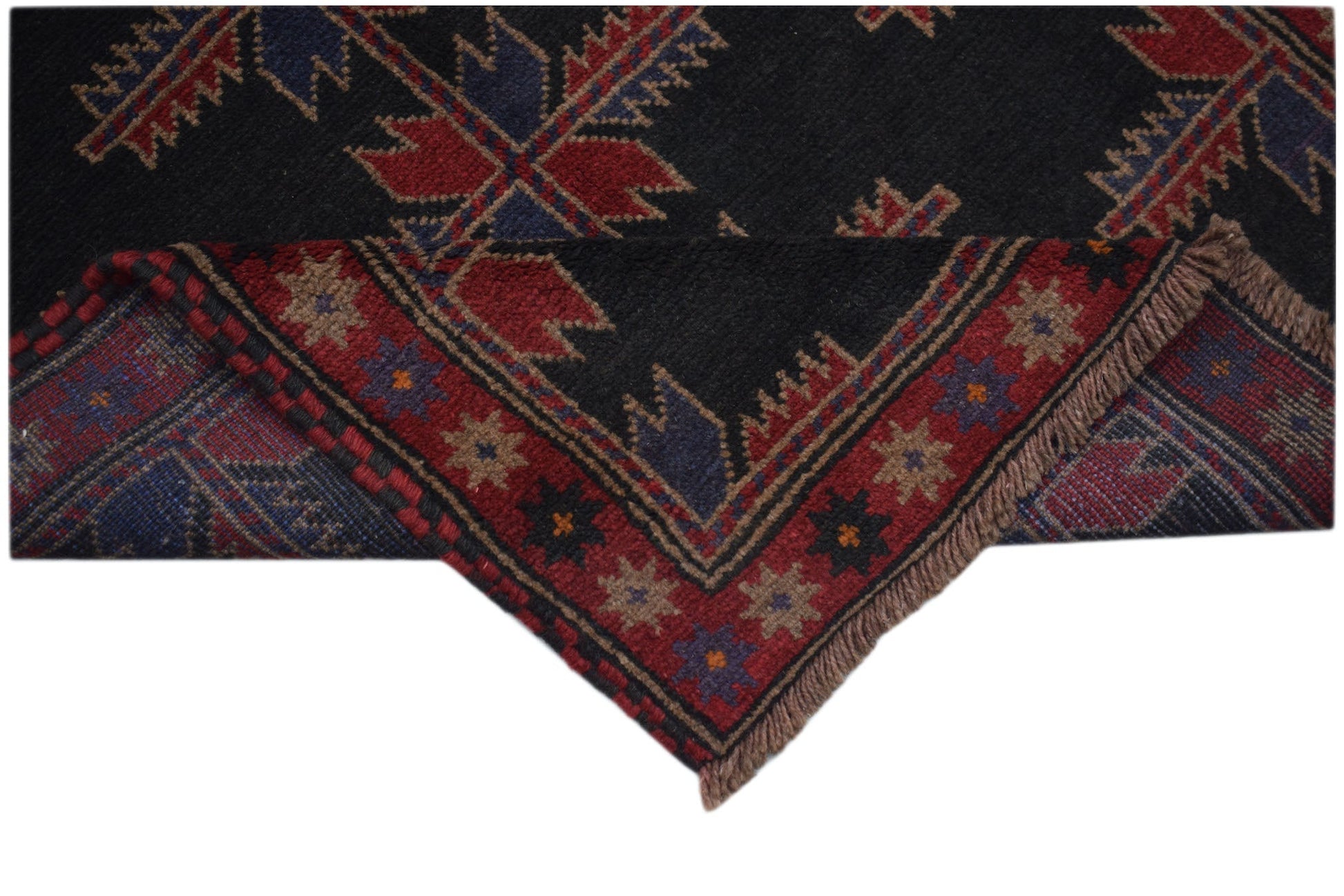 A handmade Afghan Baluch rug featuring traditional geometric patterns in red, blue, and black.