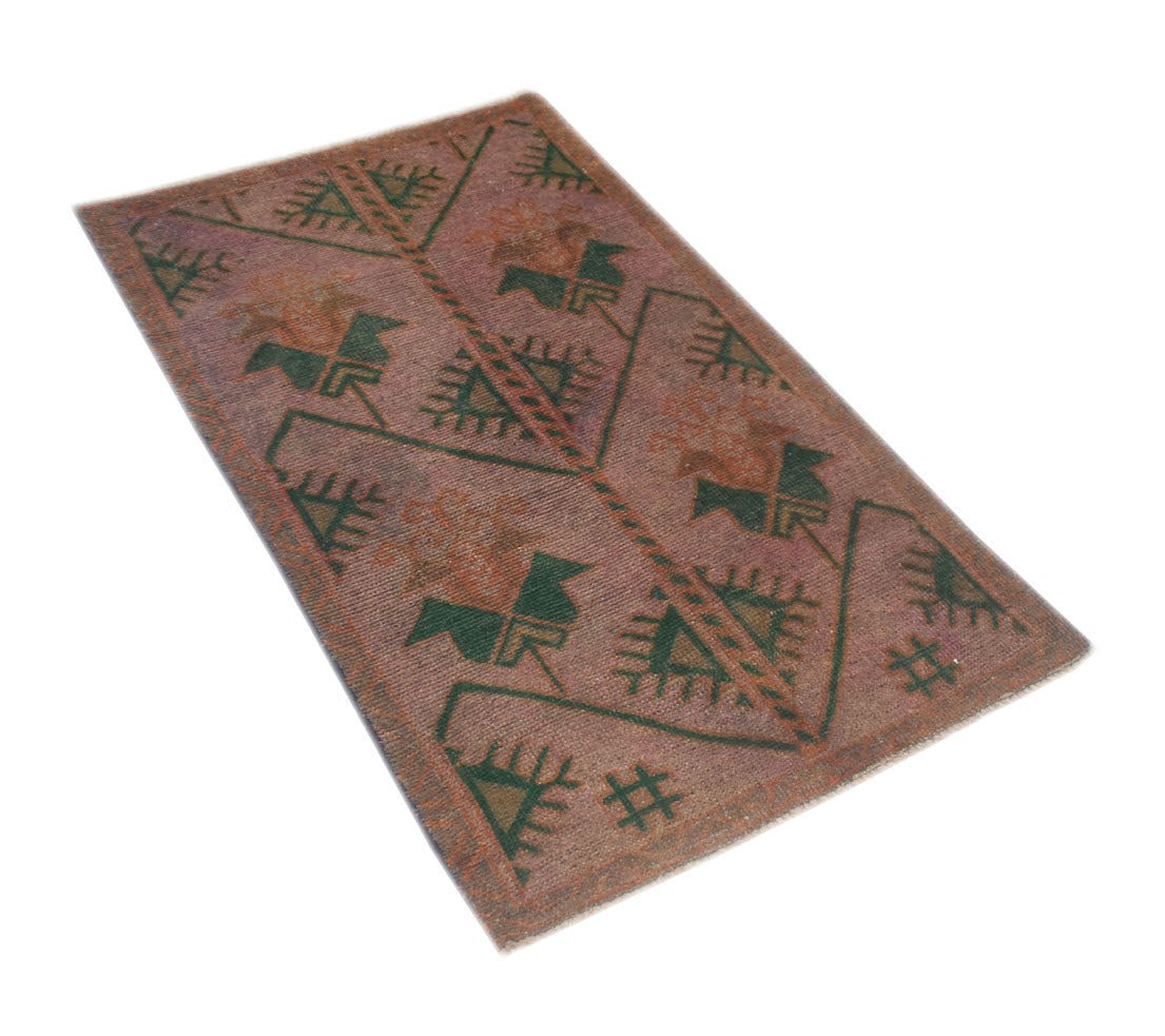 An Afghan Baluch rug featuring a geometric pattern in muted red and green wool.