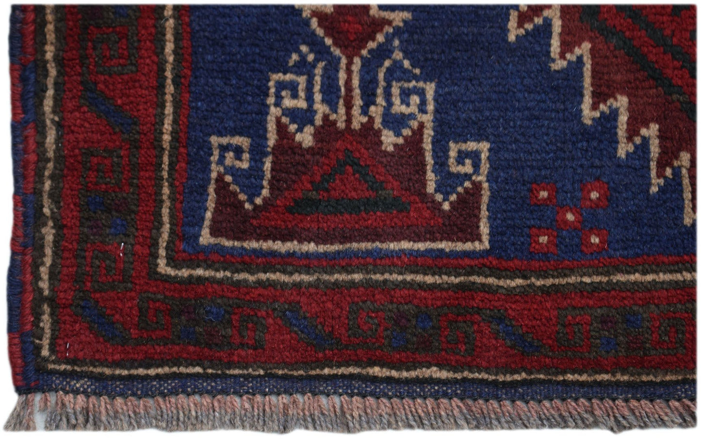 A handmade Afghan Baluch rug featuring geometric patterns in deep red, blue, and brown tones.