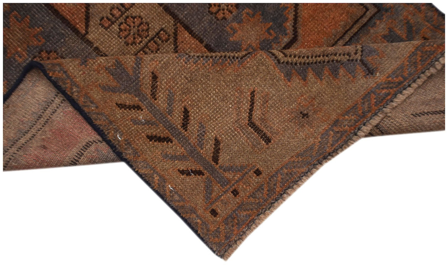 A handmade Afghan Baluch rug featuring geometric patterns in shades of brown and muted blue.