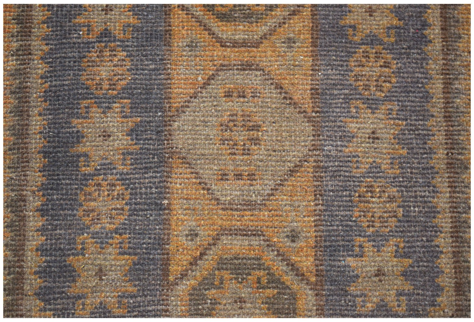 A handmade Afghan Baluch rug featuring geometric patterns in shades of brown and orange.