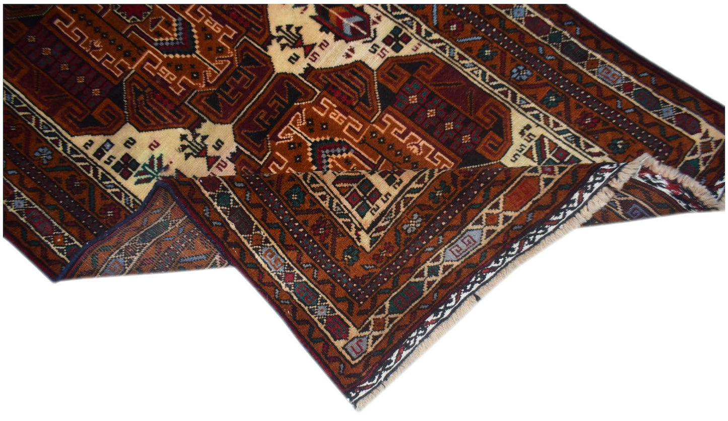 A vintage handmade Afghan Baluch rug featuring intricate geometric patterns in deep red and brown.