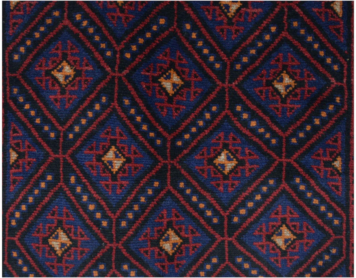 Handmade Afghan Baluch rug featuring a repeating diamond pattern in dark blue, red, and ivory.