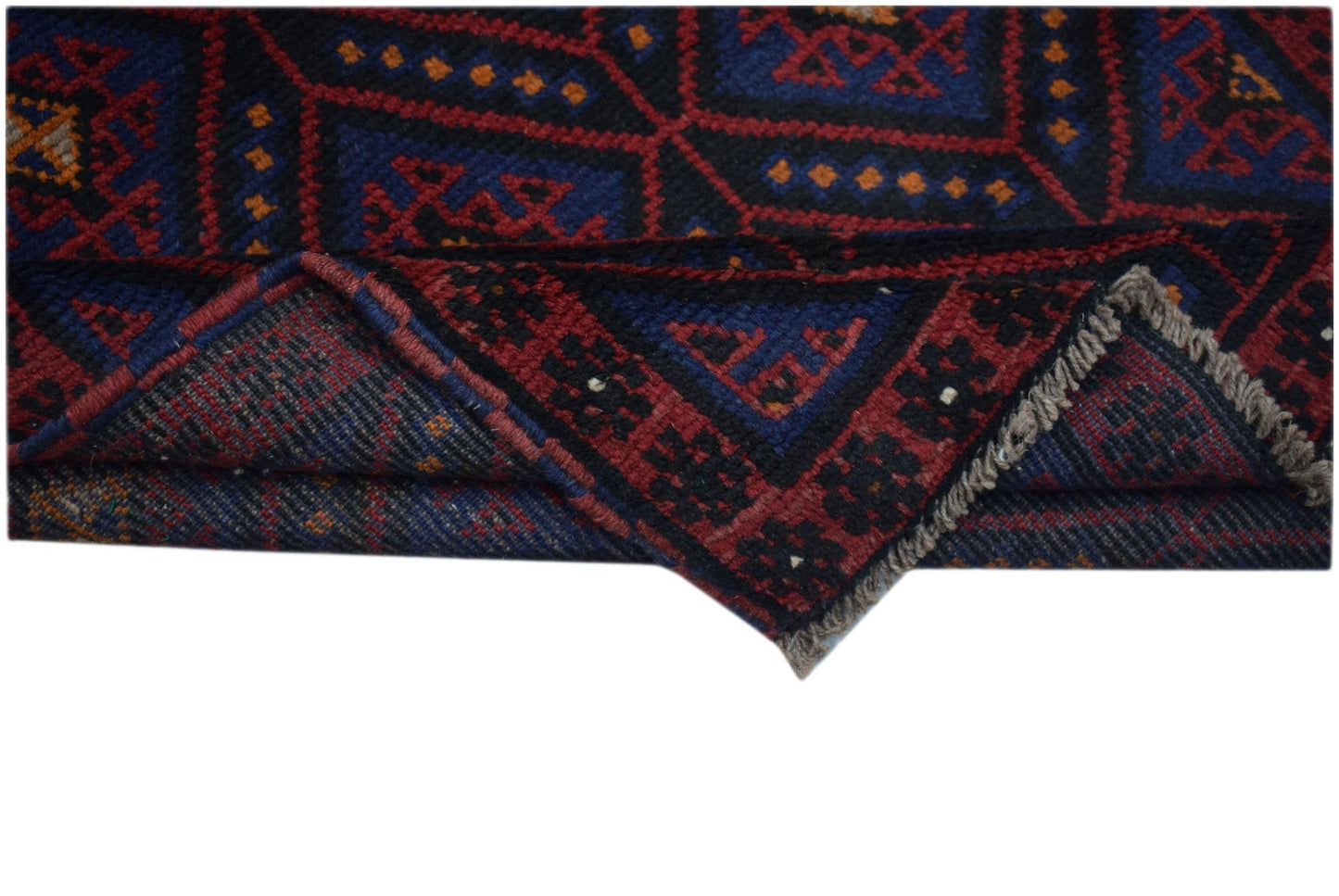 A handmade Afghan Baluch wool rug featuring a geometric pattern in dark red, blue, and black.