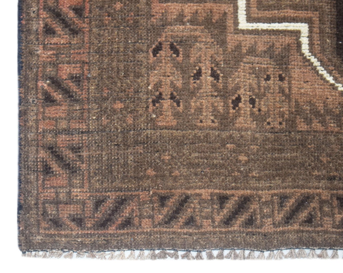 A close-up of a handmade Afghan Baluch rug featuring brown geometric patterns and a fringed edge.