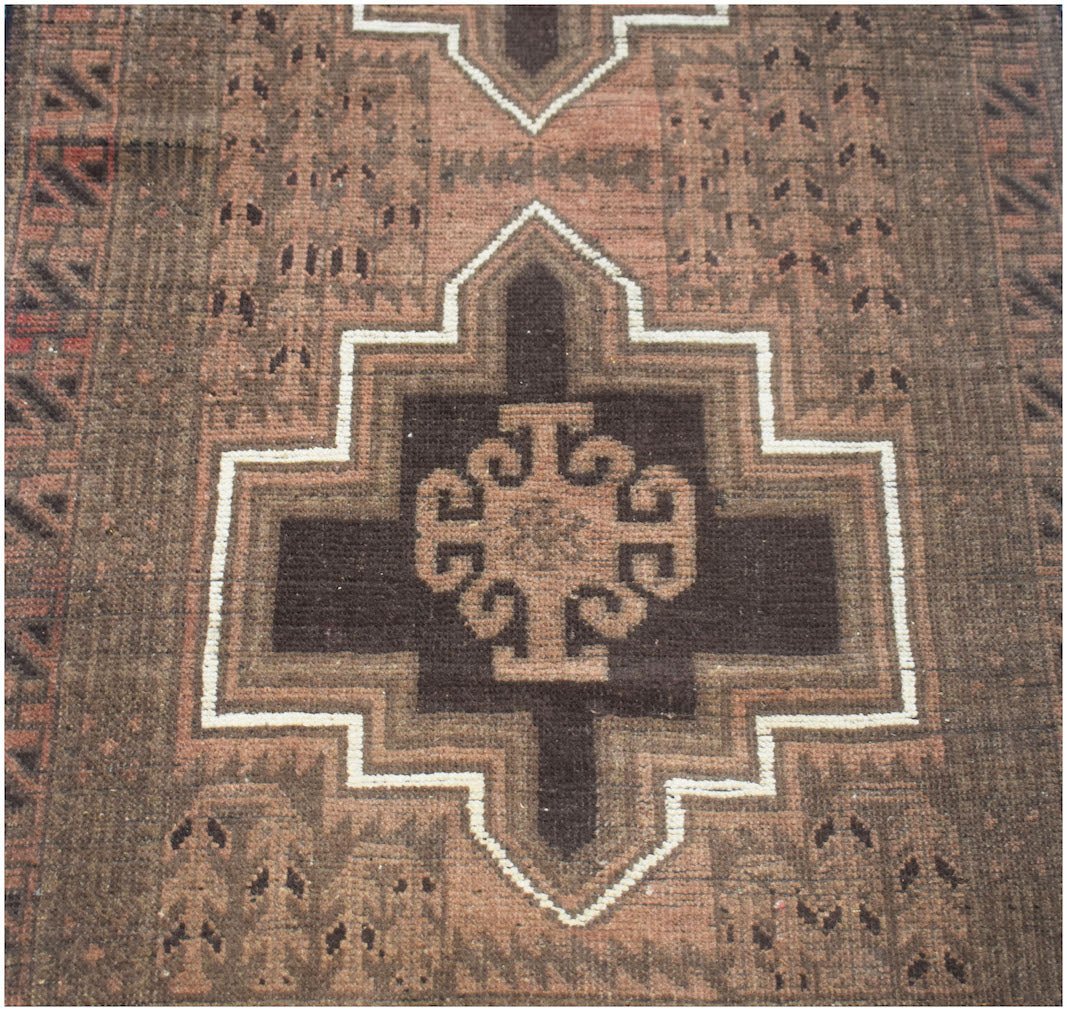 Handmade Afghan Baluch wool runner rug featuring a geometric brown and tan pattern.