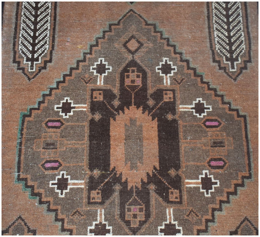 Handmade Afghan Baluch rug featuring a geometric brown and orange diamond pattern.