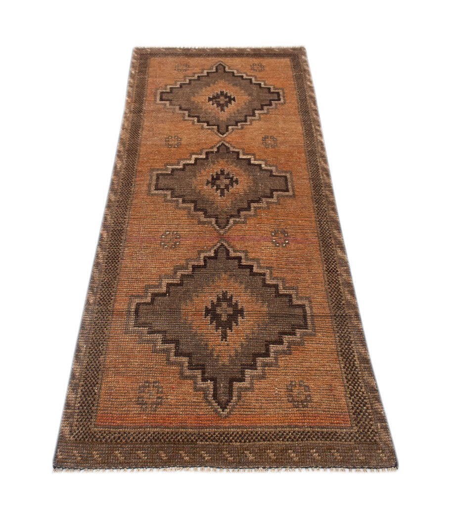 Handmade Afghan Baluch runner rug featuring three dark geometric medallions on a rust orange field.