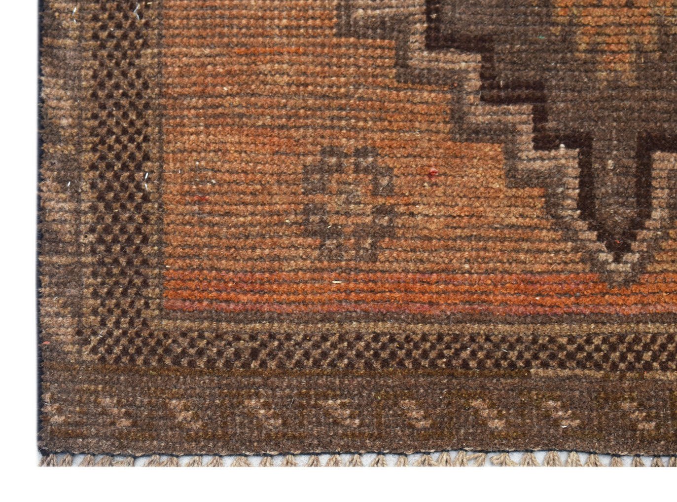 A handmade Afghan Baluch rug featuring a geometric brown and orange pattern with a fringed edge.