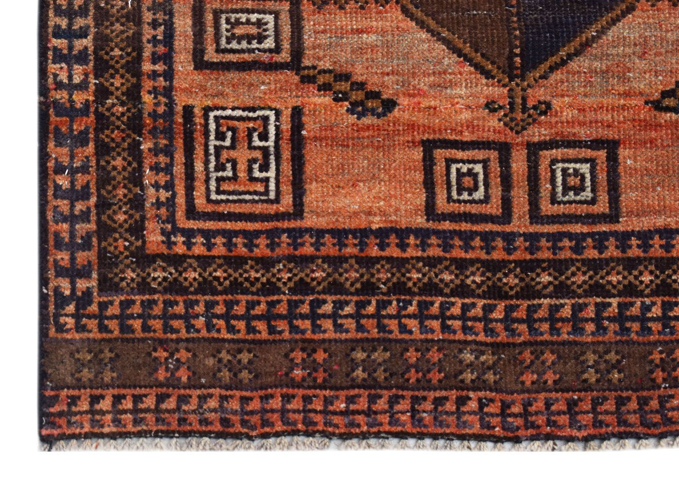 A handmade Afghan Baluch rug featuring geometric patterns in shades of orange, brown, and black.