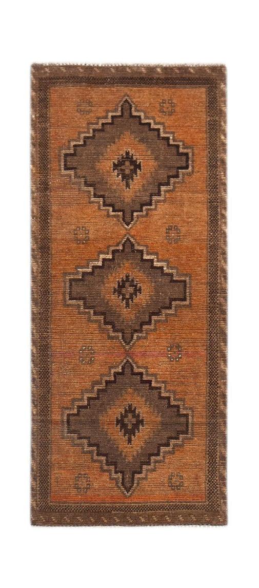 A handmade Afghan Baluch runner rug featuring three dark geometric medallions on an orange field.