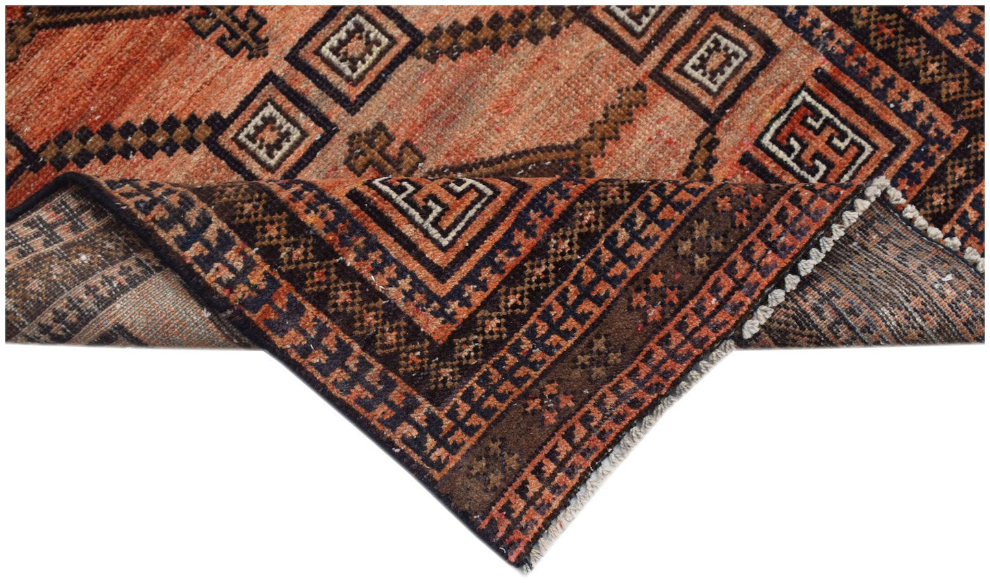 Handmade Afghan Baluch rug featuring geometric patterns in shades of orange, brown, and black.